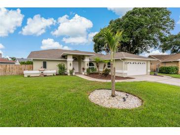 Beautiful single-story home with a manicured lawn, mature landscaping, and a spacious driveway at 8850 March Ct, New Port Richey, FL 34655