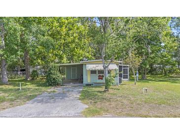 Charming home features a cozy front porch, carport, and well-maintained lawn at 9401 Bourbon St, New Port Richey, FL 34654