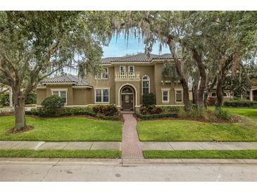 Stunning two-story home featuring a tile roof, meticulous landscaping, and a grand, arched entrance at 10531 Pontofino Cir, Trinity, FL 34655