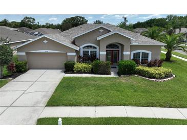 Charming single-story home with manicured lawn, mature landscaping, and a two-car garage at 22316 Red Jacket Ln, Land O Lakes, FL 34639