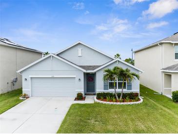Charming single-story home with well-manicured lawn, landscaped garden, and a two-car garage at 2572 Garden Plum Pl, Odessa, FL 33556