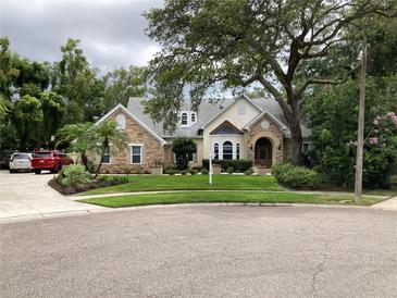 Charming stone and stucco home with mature landscaping and a well-manicured front lawn at 2880 Chelsea N Pl, Clearwater, FL 33759