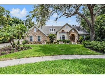 Charming stone and stucco home featuring manicured lawn and mature landscaping at 2880 Chelsea N Pl, Clearwater, FL 33759
