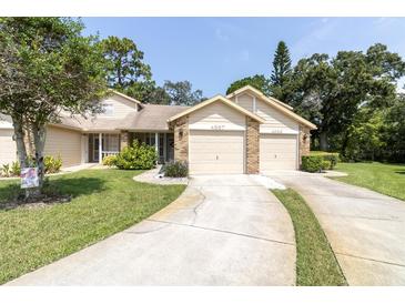 Charming home featuring attached two-car garage and well-maintained lawn and manicured shrubbery at 4557 Glen Holw, New Port Richey, FL 34653