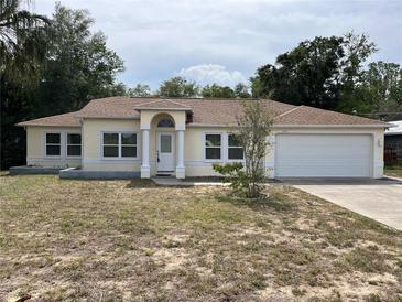 Charming single-story home featuring an attached two-car garage and well-lit entryway at 8291 Weeping Willow St, Brooksville, FL 34613