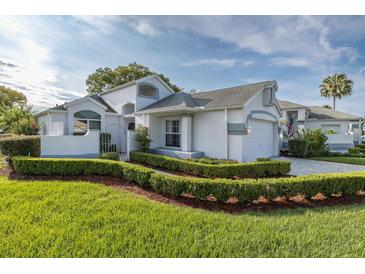 Beautiful single-Gathering home featuring manicured landscaping, a two-car garage, and a charming gated entrance at 1084 Vista Fina Ct, Spring Hill, FL 34608