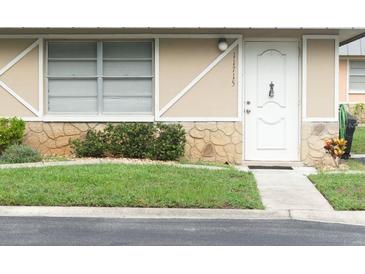 Charming single-story home with a well-maintained lawn, stone accents, and a welcoming white front door at 11715 Boynton Ln # 74B, New Port Richey, FL 34654