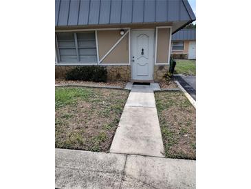 Inviting front entrance features stone accents, neutral paint, and walkway at 11715 Boynton Ln # 74B, New Port Richey, FL 34654