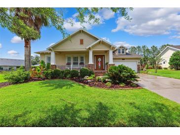 Charming single-story home featuring a well-manicured lawn, covered porch, and lush landscaping at 19531 Mossy Oak Ct, Brooksville, FL 34601