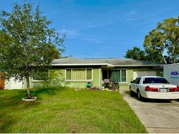 Charming single-story home features a well-maintained lawn and a private driveway at 2016 Woodward Ave, Dunedin, FL 34698