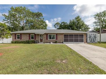 Charming single-story brick home with well-maintained lawn and covered garage at 27263 Warner Ave, Brooksville, FL 34602
