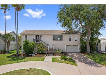 Charming two-story home with landscaped yard and a circular driveway on a sunny day at 4048 Bluefish Dr, Hernando Beach, FL 34607