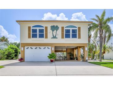 Charming two-story coastal home with a garage, carport, and palm tree accents at 4460 Flounder Dr, Hernando Beach, FL 34607