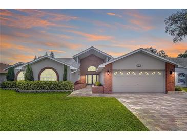 Charming home with manicured lawn, brick accents, arched windows and paved driveway at 5249 Wellfield Rd, New Port Richey, FL 34655