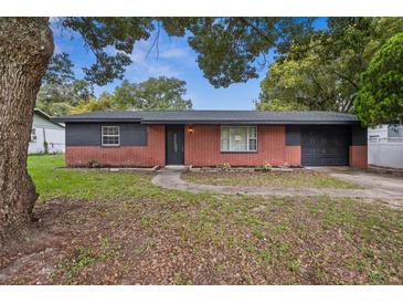 Charming single-story home features a brick facade, dark trim, and a well-maintained lawn at 5323 23Rd St, Zephyrhills, FL 33542