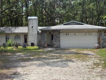 Ranch home with stone accents, gray roof and a two car garage in a treed neighborhood at 7239 Lykes Dublin Rd, Brooksville, FL 34601