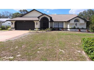 Well-maintained single-story home with a two-car garage and drought resistant landscaping at 10244 Hoover St, Spring Hill, FL 34608