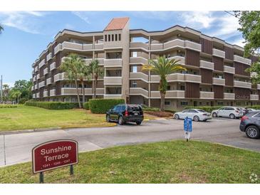Multi-story condo complex with palm trees and well-maintained landscaping on a sunny day at 1243 S Martin Luther King Jr Ave # C505, Clearwater, FL 33756