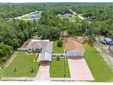Expansive aerial view of home showcasing the spacious lot, detached garage, and proximity to surrounding trees at 13444 English Parrot Rd, Brooksville, FL 34614