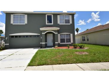 Two-story home featuring an attached two-car garage, arched entryway, and verdant lawn at 15160 Durango Cir, Brooksville, FL 34604