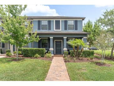 Inviting two-story home featuring a lush landscaped front yard and covered entryway at 17316 Cruiser Bnd, Land O Lakes, FL 34638