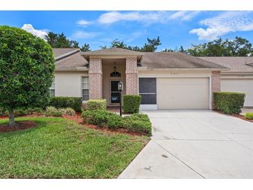 Charming single-story home with well-manicured lawn and inviting brick-accented entrance at 2165 Springmeadow Dr, Spring Hill, FL 34606