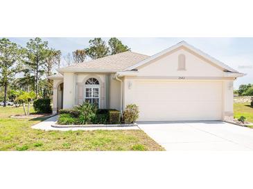 Charming single-story home with a two-car garage, manicured lawn and mature landscaping at 2542 Sandy Hill Ct, Holiday, FL 34691