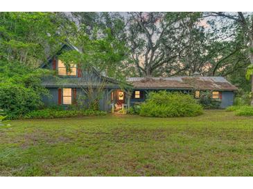 Charming home with a cozy front porch, beautiful landscaping, and a lush green lawn at 3270 Endsley Rd, Brooksville, FL 34604