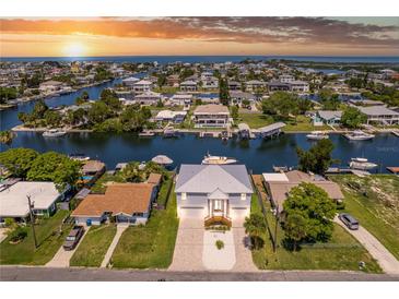 Stunning aerial view of waterfront homes, docks and boat lifts on canals at sunset in Hernando Beach at 4469 Bahama Dr, Hernando Beach, FL 34607