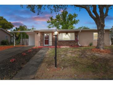 Charming single-story home with a brick facade, mature trees, and a well-maintained front yard and covered carport at 4537 Cynthia Ln, Spring Hill, FL 34606