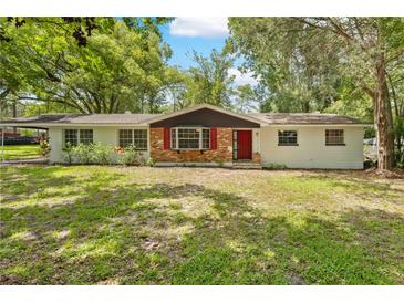 Charming single-story home with brick accents, a red front door, and a well-maintained lawn at 507 Jewel St, Brooksville, FL 34601
