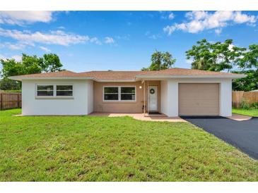 Charming single-story home featuring a well-maintained lawn and inviting curb appeal on a sunny day at 7316 Tangelo Ave, Port Richey, FL 34668