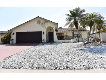 Charming single-story home features decorative stucco work, desert landscaping, and a two car garage at 9003 Lido Ln, Port Richey, FL 34668