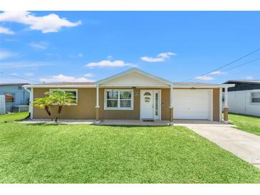 Charming single-story home with a well-manicured lawn and a cozy, covered front porch, inviting curb appeal at 9016 Unicorn Ave, Port Richey, FL 34668
