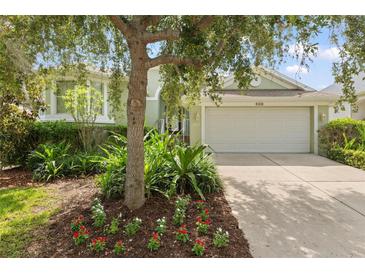 Charming single-story home with lush landscaping and a two-car garage and beautiful front yard at 1010 Teal Pointe, Tarpon Springs, FL 34689