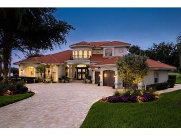 Beautiful two-story home featuring a red tile roof, a brick driveway, and lush landscaping at 10342 Altrara Way, Trinity, FL 34655