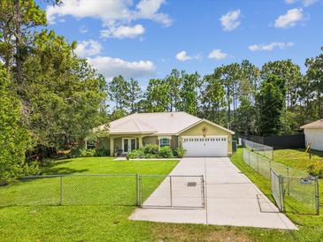 Charming home featuring a metal roof, fenced yard, and well-maintained landscaping, offering curb appeal and security at 12229 Barnevelde Rd, Weeki Wachee, FL 34614