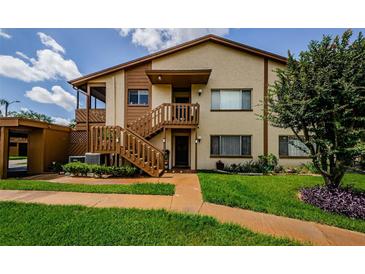 Inviting two-story condo with well-maintained lawn and wood staircase leading to the entrance at 3841 Lanyard Ct # B, New Port Richey, FL 34652