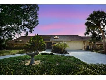 Charming single-story home featuring a well-manicured lawn, mature trees, and a two-car garage at 4269 River Birch Dr, Spring Hill, FL 34607
