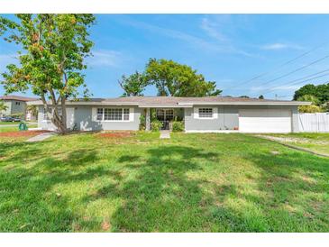 Charming single-story home with a well-manicured lawn, mature trees, and an attached garage at 6795 23Rd S St, St Petersburg, FL 33712