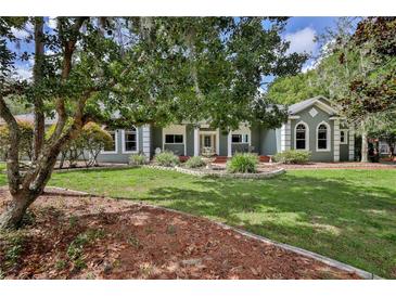 Inviting home with a landscaped front yard, mature trees, and charming fountain at 11510 Lakeview Dr, New Port Richey, FL 34654