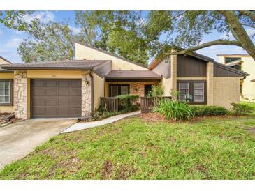 Charming townhome with a well-maintained front yard and stone accents on the facade at 2101 Sunset Point Rd # 201, Clearwater, FL 33765