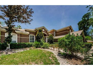 Charming brown two-story home with lush landscaping and a well-maintained front yard at 2987 Wentworth Way, Tarpon Springs, FL 34688
