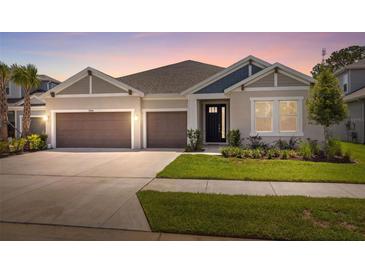Charming single-story home featuring a well-manicured lawn, two-car garage, and neutral-toned exterior at 33466 Landsman Loop, Wesley Chapel, FL 33543