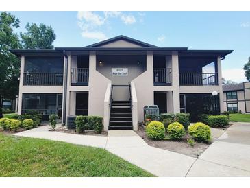 Two-story condo building with screened porches, lush landscaping, and well-maintained grounds at 4015 Angel Oak Ct # 201, Tampa, FL 33613