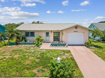 Charming single-story home featuring a one-car garage, tropical landscaping and lovely curb appeal at 4567 Great Lakes S Dr, Clearwater, FL 33762