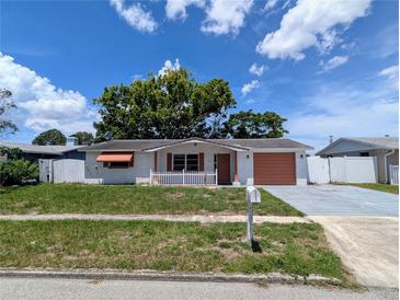 Quaint single story home with a white picket fence, charming details, and well-kept landscaping at 4853 Alcea St, New Port Richey, FL 34652