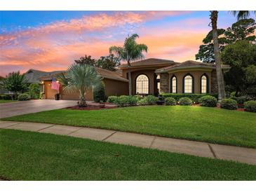 Stunning home featuring mature landscaping, elegant architectural details, and a well-manicured lawn at 5121 Delacroix Dr, Brooksville, FL 34604