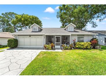 Charming single-story home with a well-maintained lawn, screened porch, and two-car garage at 6282 Darien Way, Spring Hill, FL 34606