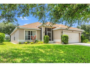 Charming single-story home with well-manicured lawn, landscaping, and a screened porch entry at 7059 Wirevine Dr, Brooksville, FL 34602